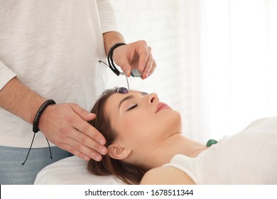 Young Woman During Crystal Healing Session In Therapy Room