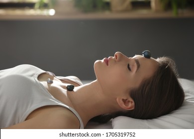 Young Woman During Crystal Healing Session In Therapy Room