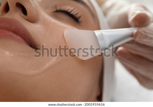 Young woman during face peeling procedure in
salon, closeup