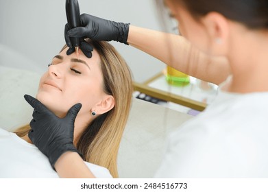 Young woman during procedure of permanent eyebrow makeup, closeup - Powered by Shutterstock