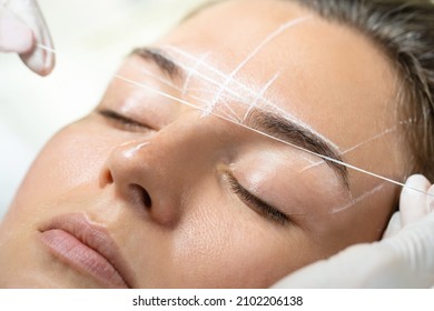 Young woman during professional eyebrow mapping procedure before permanent makeup - Shutterstock ID 2102206138