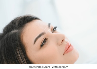 Young woman during professional eyebrow mapping procedure - Powered by Shutterstock