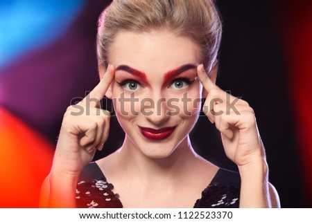 Young woman with dyed eyebrows in colorful projectors lights