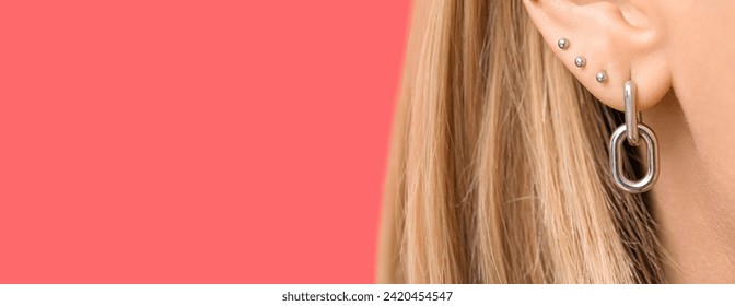 Young woman with ear piercing on pink background, closeup. Banner for design - Powered by Shutterstock