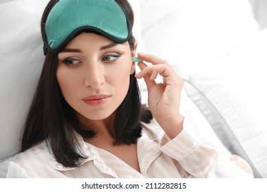 Young Woman With Earplugs In Bedroom