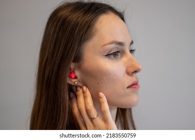 A Young Woman With Earplugs In Her Ears