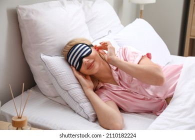 Young Woman With Earplugs Sleeping In Bed