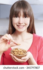 Young Woman Eating Almonds From Bowl