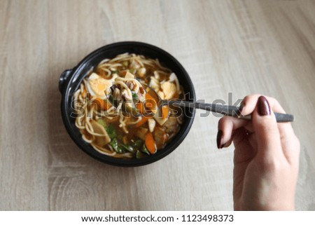 Young woman eating asian soup ramen