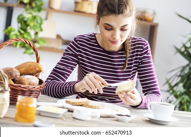 Young Woman Eating Bread With Butter