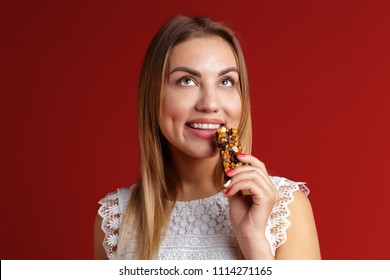 Young Woman Eating Cereal Candy Bar