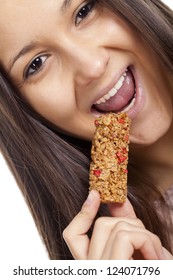 Young Woman Eating Cereal Candy Bar, Isolated On White