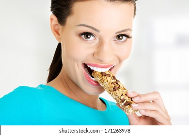 Young Woman Eating Cereal Candy Bar