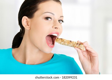 Young Woman Eating Cereal Candy Bar