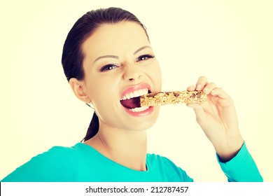 Young Woman Eating Cereal Candy Bar, Isolated On White