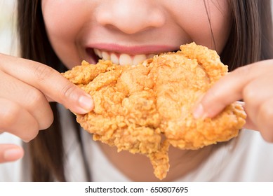 Young Woman Eating Deep Fried Chicken - Close Up Shot