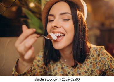 Young Woman Eating Delicious Tiramisu In A Cafe