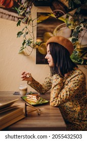 Young Woman Eating Delicious Tiramisu In A Cafe