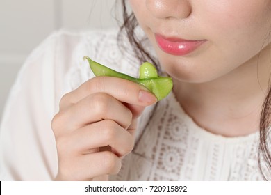 Young Woman Eating Edamame