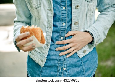 Young Woman Eating Fast Food Outdoor And Feels Very Bad, She Has Stomach Pain