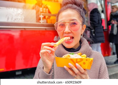 Young Woman Eating A  French Fries Street Food In Germany