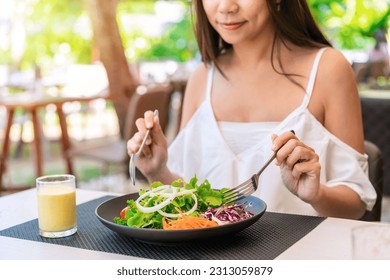 Young woman eating healthy salad at restuarant, Healthy lifestyle and diet concept