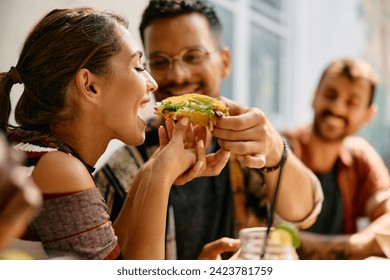 Young woman eating her boyfriend's tacos during a lunch in Mexican restaurant. - Powered by Shutterstock