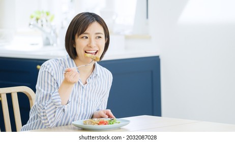 Young Woman Eating At Home