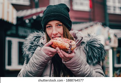 Young Woman Eating Hot Dog. Street Food Outdoor Winter