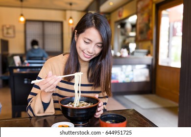 Young Woman Eating Japanese Udon In Restaurant