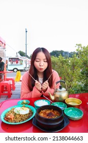 Young woman eating Korean food with Jajangmyeon and Kimchi soupat seoul, south korea.