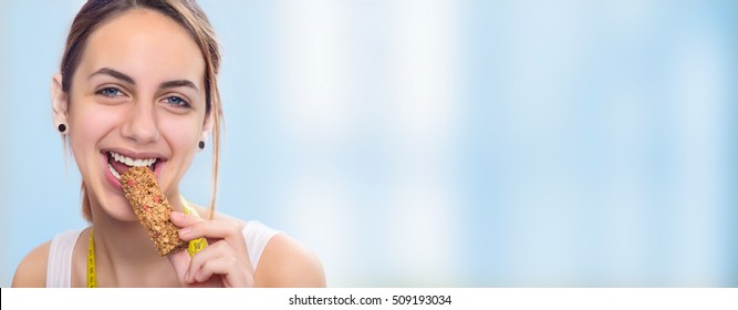 Young Woman Eating Muesli Bar . 