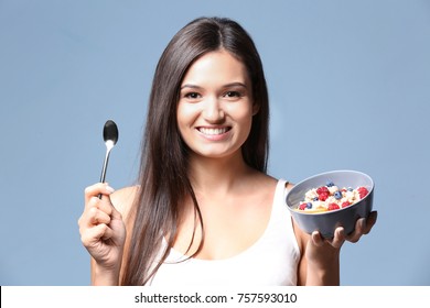 Young Woman Eating Oatmeal On Light Background