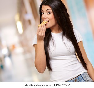 Young Woman Eating Piece Of Granola Bar, Indoor