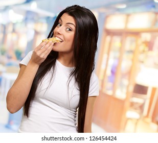 Young Woman Eating Piece Of Granola Bar, Indoor