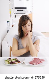 young woman eating salad and meat, concept of choosing