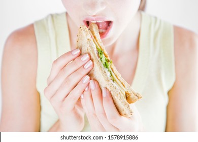 A Young Woman Eating A Sandwich