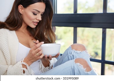 Young Woman Eating Soup By The Window.