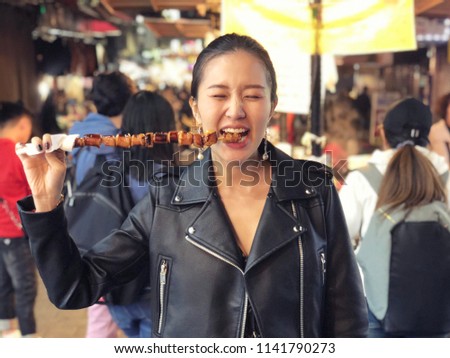 Young woman eating Steamed Octopus Legs at  at Myeong-dong street food, Seoul, South Korea