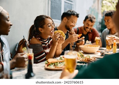 Young woman eating tacos while being with friends in Mexican restaurant.  - Powered by Shutterstock