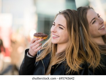 Young Woman Eating Tasty Donut Outdoor - Reflection In Shop Window