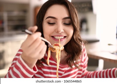 Young Woman Eating Tasty Pasta At Home