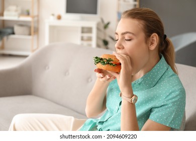 Young Woman Eating Tasty Vegan Burger At Home