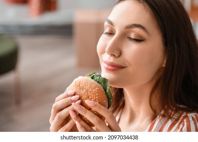 Young Woman Eating Tasty Vegan Burger At Home