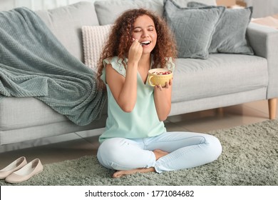 Young Woman Eating Tasty Yogurt At Home