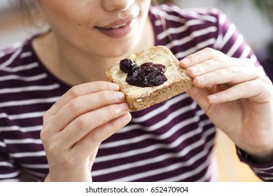 Young Woman Eating Toast Bread With Jam