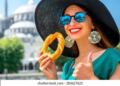 Young Woman Eating Turkish Bagel In Istanbul, Turkey. Traditional Turkish Street Food.