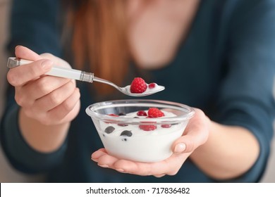 Young Woman Eating Yogurt, Closeup