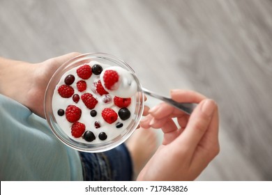 Young Woman Eating Yogurt At Home