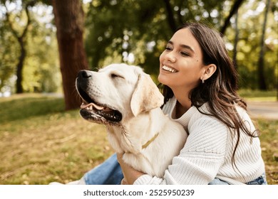 A young woman embraces her dog warmly, enjoying a peaceful autumn day in the park.